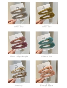 Close-up of acetate waterdrop hair clips in glitter and marble patterns on cards
