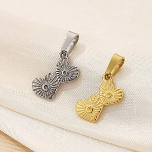 Detailed close-up of gold and silver heart-shaped metal pendants with radial texture