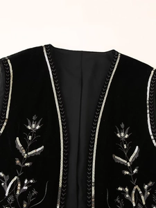 Close-up of floral embroidery and silver sequins on black velvet ethnic waistcoat
