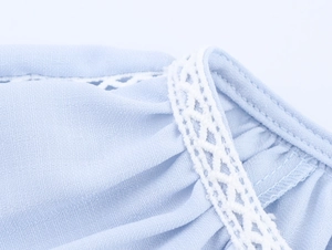 Detail of light blue fabric texture featuring delicate white lace trim and stitching