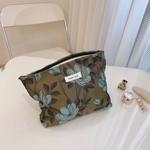 Detail of floral jacquard makeup bag in olive green with simple wish label on top