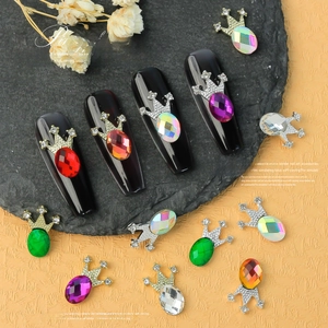 Detailed close-up of colorful crown-shaped nail art charms with sparkling rhinestones