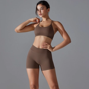 Detail of seamless dark brown cross-back sports bra and high-waisted gym shorts set
