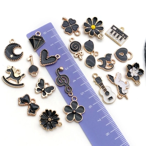 Assorted black and white enamel DIY pendants with heart, moon, and floral designs for jewelry