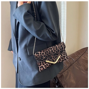 Detail of leopard print envelope clutch with gold V-shape buckle and chain strap