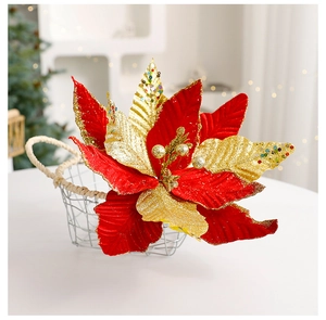Close-up of red and gold velvet poinsettia in a basket with bokeh Christmas tree background