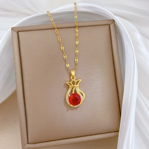 Elegante Goldhalskette mit rotem Edelstein-Glücksbeutel und Kristallen auf weißer Seide