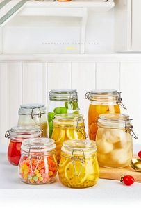 Kitchen setup of multi-size glass storage jars with airtight metal clamps and seals