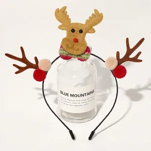 Detail of Christmas reindeer headband with plush antlers and festive pom poms