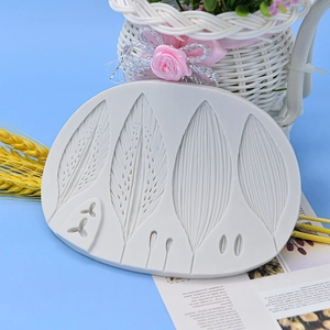 Grey silicone leaf mold for DIY cake decorating and crafts on a blue background