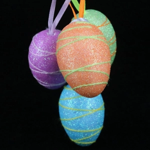 Glittery Easter egg ornaments in purple, orange, blue, and green with hanging ribbons