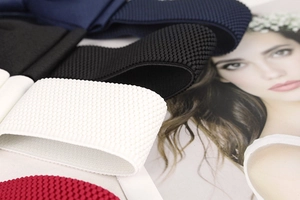 Close-up of textured knit elastic belts in white black navy and burgundy colors