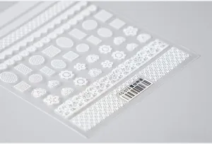 Macro detail of TS-073 white 5D lace nail stickers with floral and mesh patterns