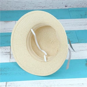 Detail of woven straw sun hat for girls showing fine texture and white elastic chin strap