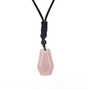 Detailed view of a hexagonal pink crystal pendant with a black braided cord necklace