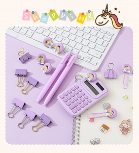 Flat lay of purple stationery set with calculator, pen, and clips on grid paper