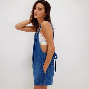 Women's summer loose denim romper with adjustable straps and side pockets on studio model