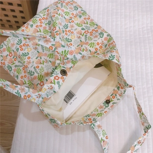 Détail du sac cabas floral en toile avec bouton pression en bronze et doublure spacieuse