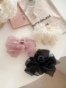 Detailed view of mesh bow hair claws in pink, beige and black chiffon on white background