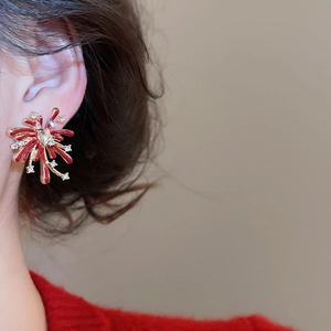Macro view of fireworks stud earrings with red enamel petals and zircon crystal accents
