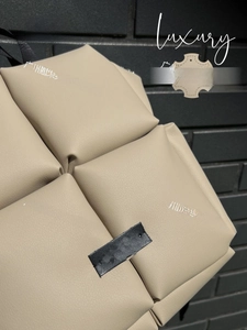 Détail de la texture en cuir matelassé beige sur un sac à dos tendance spacieux