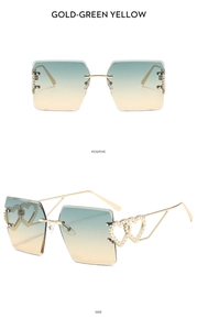 Detail view of rimless square sunglasses with gold heart hollow temples and gradient lenses