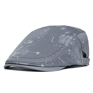 Close-up of gray newsboy hat with white paint splatter texture and side buckle