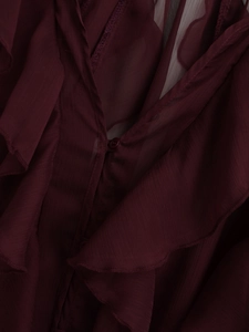 Close-up of wine red chiffon blouse showing layered ruffles and matching buttons