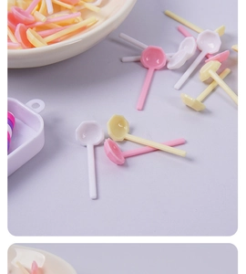 Macro detail of colorful miniature plastic spoons in pastel pink, white and yellow shades