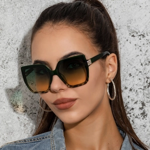 Macro detail of cat-eye sunglasses featuring rhinestone accents and gradient lenses