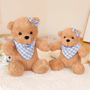 Plush brown teddy bear set with blue plaid scarf and bow tie in a cozy home setting