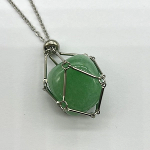 Close-up of a silver mesh cage pendant holding a natural green aventurine raw crystal