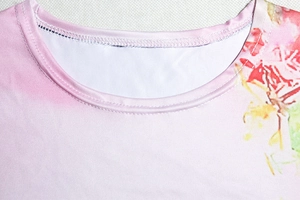 Detailed close-up of the round neckline and stitching on a pink floral summer dress