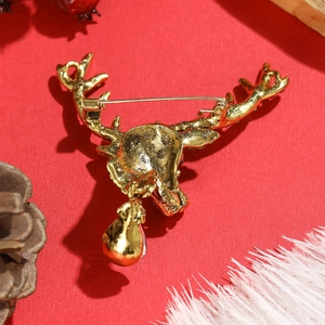 Vintage gold reindeer brooch with crystal accents and Christmas pin backing on red background