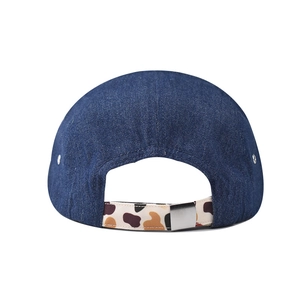 Detail of adjustable floral printed strap and metal buckle on navy denim baseball cap