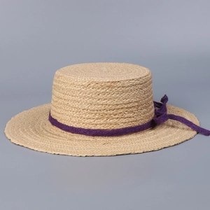Stylish summer raffia straw hat with flat top and purple ribbon bow for sun protection