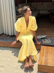 Detail of V-neck tie-up crop top and long skirt set in yellow linen for summer vacation