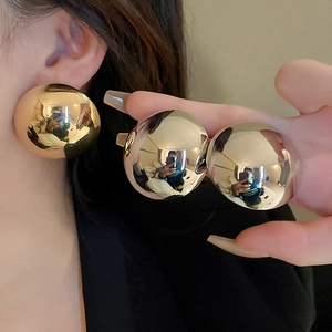 Oversized metallic sphere earrings with high-gloss finish and bold geometric design