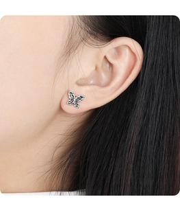 Close-up of a vintage black butterfly stud earring on a model ear, minimalist S925 silver