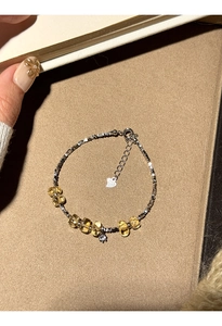 Close-up of beaded bracelet with citrine stones and silver beads on warm textured base