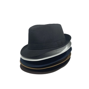 Différentes couleurs de chapeaux fedora unisexes empilés en noir, blanc et kaki