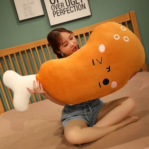 Detailed view of a giant cartoon chicken leg plush pillow being held by a model.