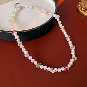 Colorful gemstone pearl necklace with lobster clasp on a dark leather background
