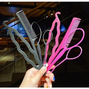 Detailed view of pink and black hair braiding tool set including combs and loops