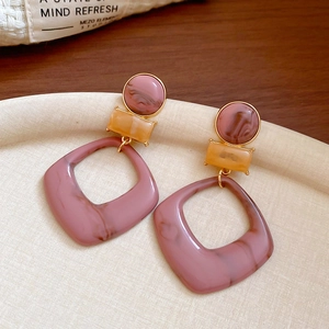 Detailed view of pink and yellow resin geometric drop earrings with silver needle posts