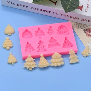Pink silicone mold for Christmas tree cakes and chocolates on a blue background