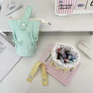 Vertical macaron pencil cases with bow detail and large capacity shown on a desk