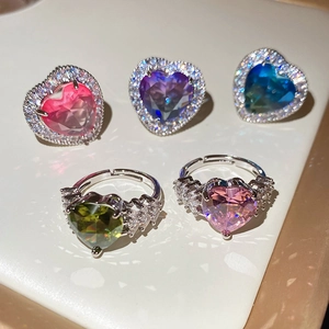 Detailed view of heart-shaped zircon rings in multiple colors with adjustable silver bands