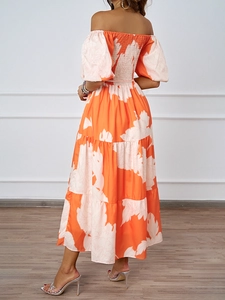 Détail de la robe fleurie orange montrant la jupe à volants et le dos élastique froncé