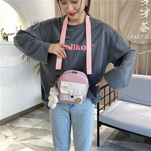 Détail du sac bandoulière en toile rose avec sangle réglable et charmant ours en peluche